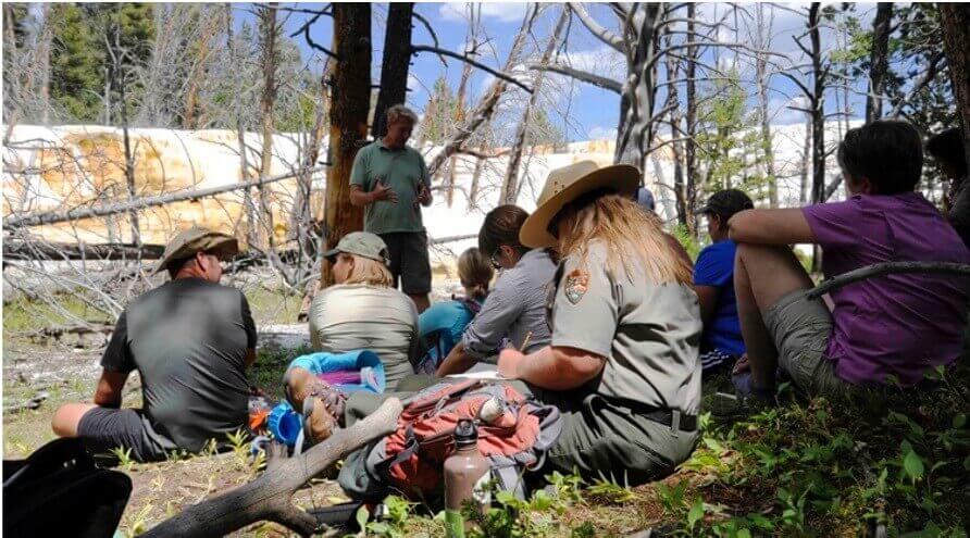 Professor Bruce Fouke teaching a group of participants in front of a Mammoth Hot Springs feature